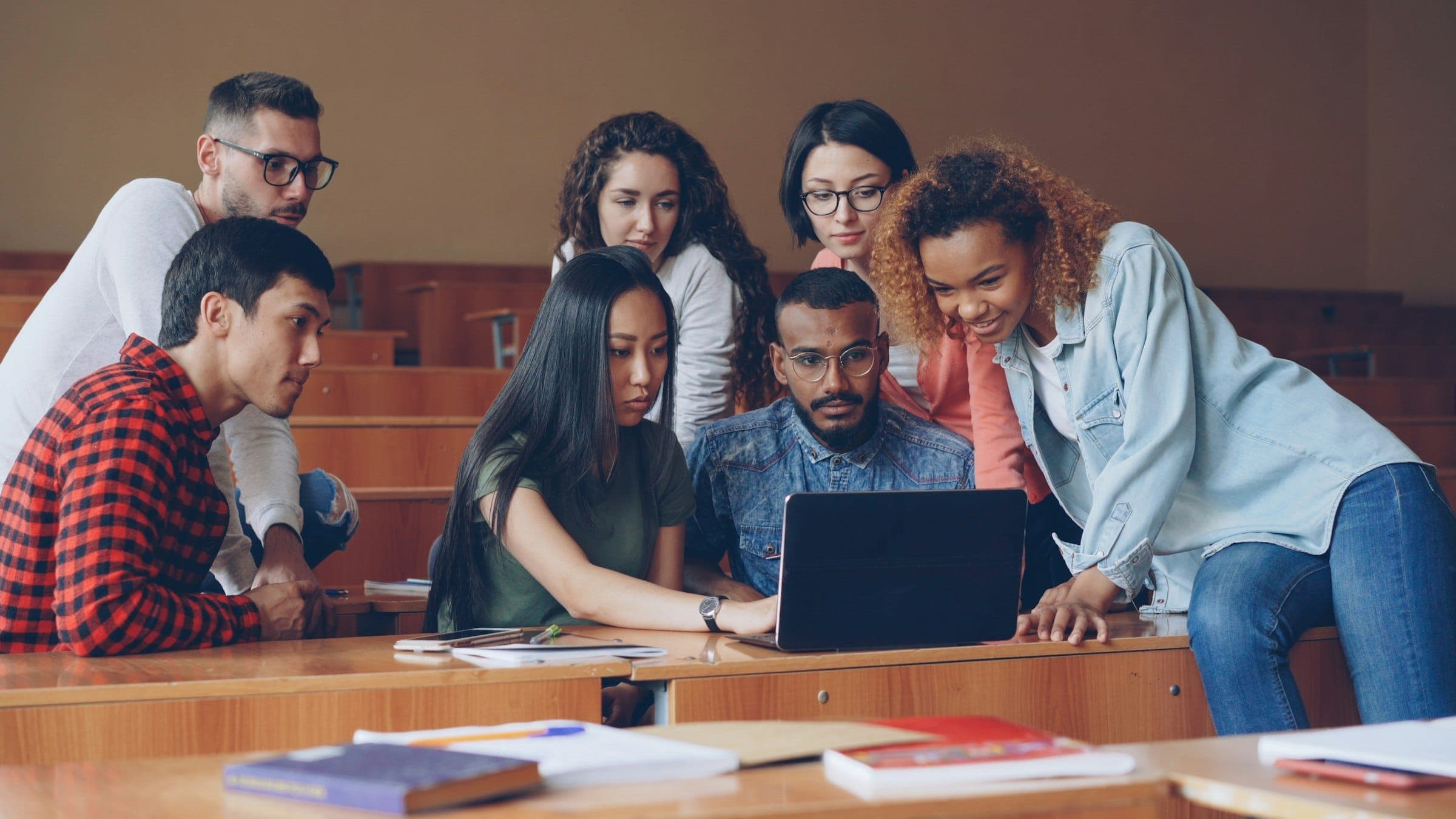 Groep studenten werkt samen aan een laptop